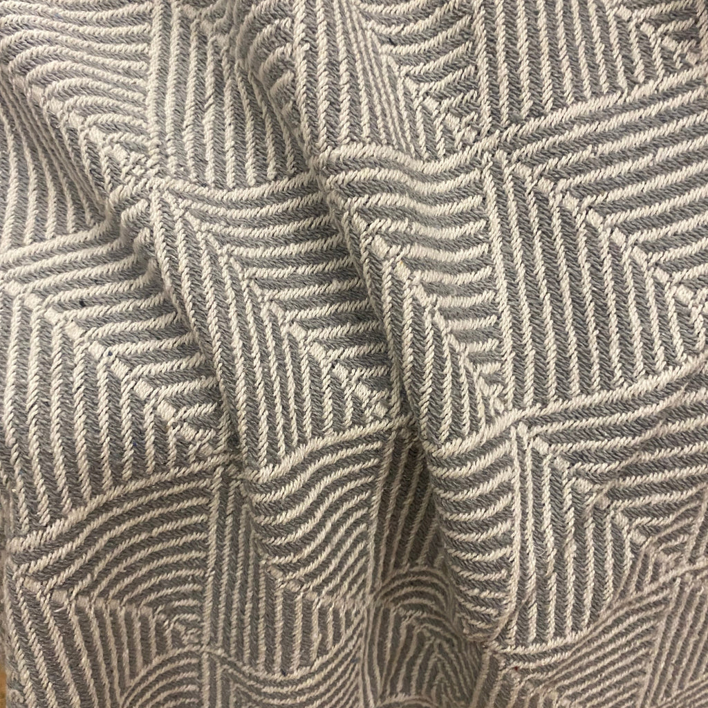 Close-up of a woven textile with a geometric basketweave pattern in taupe and gray.