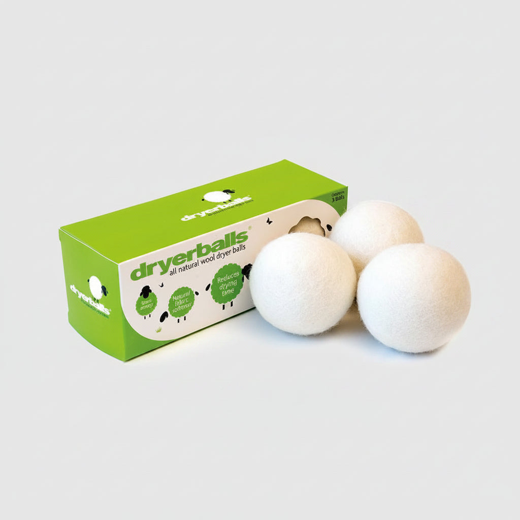 A set of three white wool dryer balls next to their green packaging box, which has the text 'Dryer Balls' and 'Pure Wool' on it.