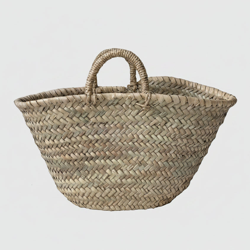 A beige rope handle shopping basket made with palm leaves, featuring two handles at the top.