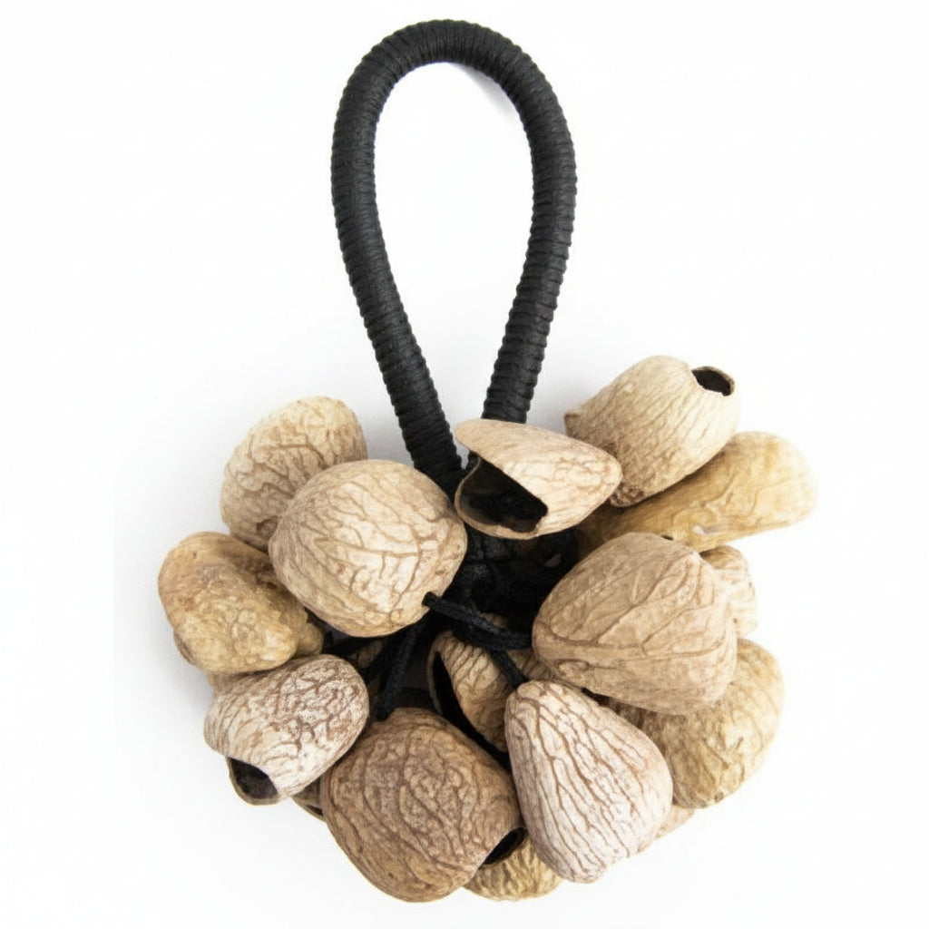 A golden-colored  Pangi nut shell rattle with a black string handle.