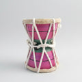 A small hand drum with a pink body, green and red stripes, and a beige-colored head, tied with a white rope.