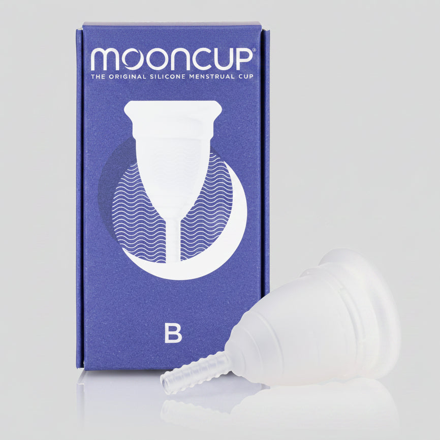A Mooncup menstrual cup in white color, displayed next to its blue packaging with the brand name and size 'B' indicated.