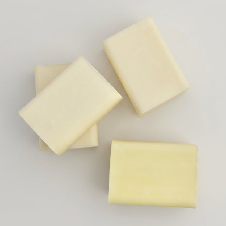 Three organic shampoo bars on a white towel background.